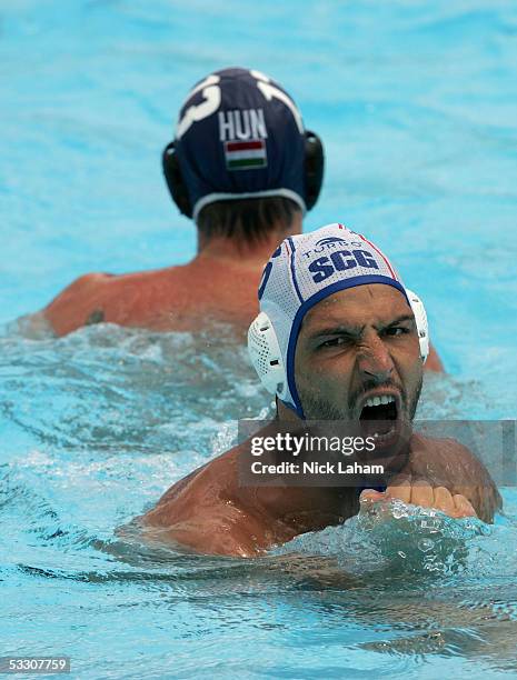 Danilo Ikodinovic of Serbia and Montenegro celebrates a goal in front of Peter Biros of Hungary in the gold medal match during the XI FINA World...