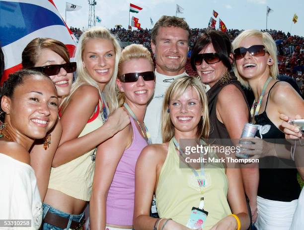 David Coulthard of Great Britain and Red Bull poses with F1 glamour girls on the grid during the Hungarian F1 Grand Prix at the Hungaroring on July...