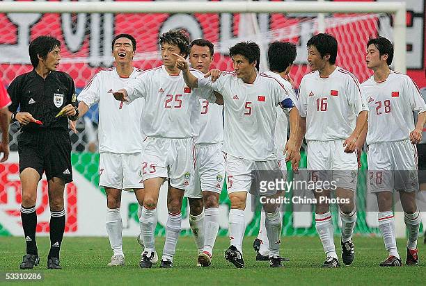Chinese players argue with the Japanese referee during their match against South Korea at the East Asian Football Champion Final Competition on July...