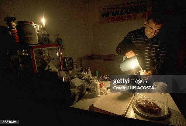 Un empleado de una cafeteria sirve jugo alumbrado por velas, en Mocoa, departamento del Putumayo, Colombia el 30 de julio de 2005. Las guerrillas de...