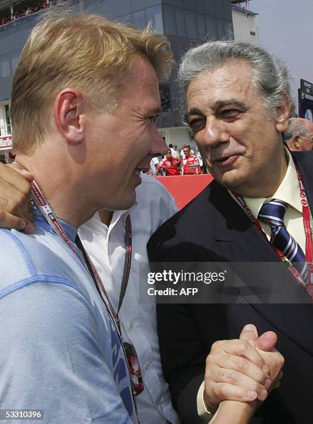 Finnish former F1 World Champion Mika Hakkinen chats with Italian singer Placido Domingo on the start grid of the Hungaroring racetrack before the...