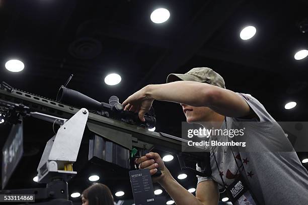 An attendee handles a Barrett Firearms Manufacturing .50 caliber sniper rifle on the exhibit floor during the National Rifle Association annual...