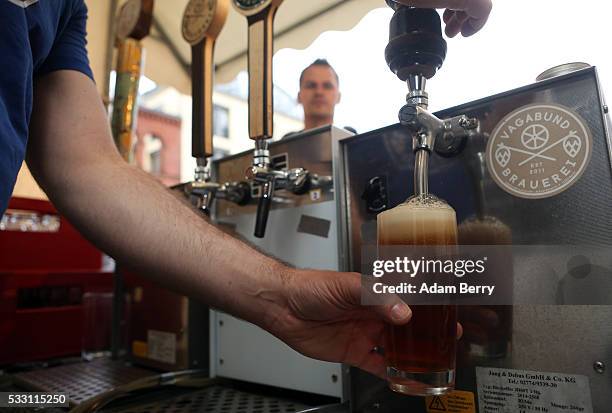 Bartender pours a beer at the Handgemacht craft beer festival in the Kulturbrauerei on May 20, 2016 in Berlin, Germany. During the 500th anniversary...