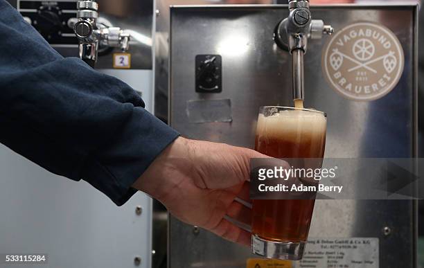 Bartender pours a beer at the Handgemacht craft beer festival in the Kulturbrauerei on May 20, 2016 in Berlin, Germany. During the 500th anniversary...