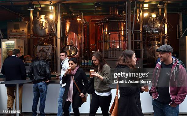 Visitors enjoy beers at the Handgemacht craft beer festival in the Kulturbrauerei on May 20, 2016 in Berlin, Germany. During the 500th anniversary...