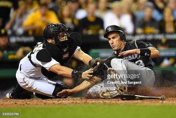 Dustin Garneau of the Colorado Rockies is tagged out at home plate by Francisco Cervelli of the Pittsburgh Pirates during the seventh inning on May...