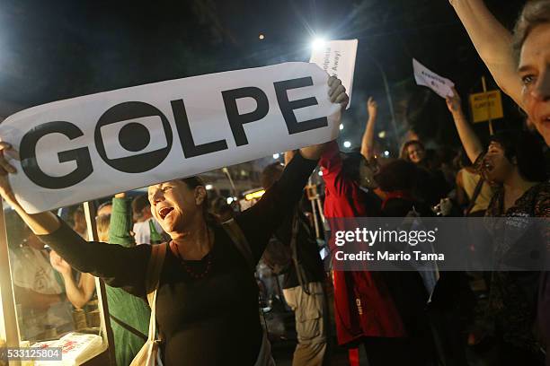 Protester holds a sign written in Portuguese referring to a 'coup' at a march against interim President Michel Temer on May 20, 2016 in Rio de...