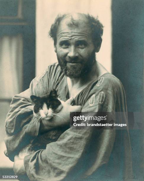 Gustav Klimt holding one of his cats in his arms, in front of his studio in Vienna, 8th district, Josefstaedter Strasse. Photography by Moriz Naehr....