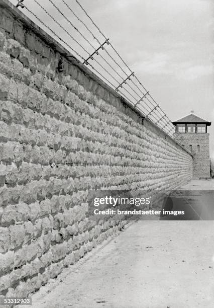 Concentration camp Mauthausen: watchtower and stone wall with barbed wire. Photography, around 1940. [Konzentrationslager Mauthausen: Wachtturm und...