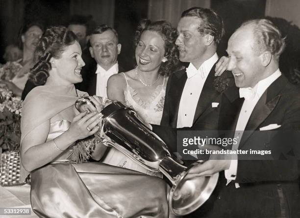 Actress Magda Schneider with Carola Hoehn, Wolf Albach-Retty and Ernst Weiser at the Filmball in Berlin. Photography. Germany. 1939. [Die...
