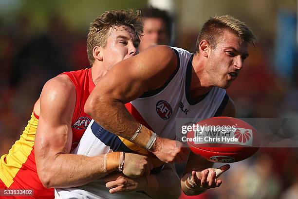 Daniel Talia of the Crows handballs while tackled by Tom Lynch of the Suns during the round nine AFL match between the Gold Coast Suns and the...