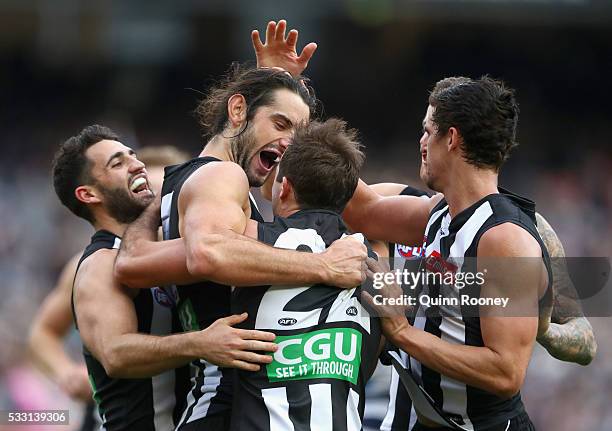 Brodie Grundy of the Magpies is congratulated by team mates after kicking a goal during the round nine AFL match between the Collingwood Magpies and...