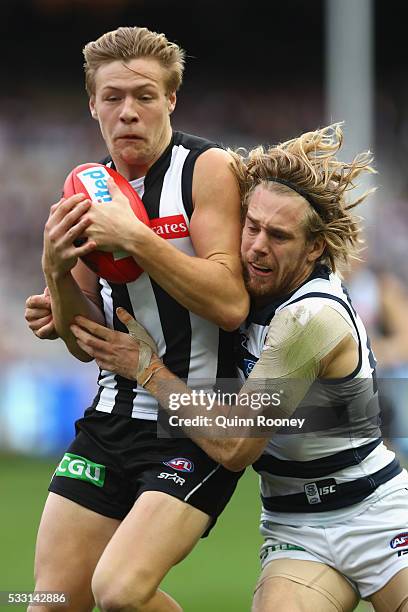 Jordan de Goey of the Magpies is tackled by Cameron Guthrie of the Cats during the round nine AFL match between the Collingwood Magpies and the...