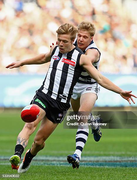 Jordan de Goey of the Magpies kicks whilst being tackled by George Horlin-Smith of the Cats during the round nine AFL match between the Collingwood...