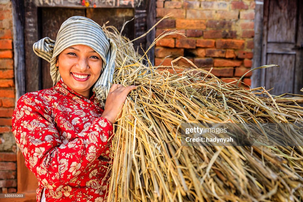 Nepali girl carrying rice straw in Bhaktapur, Nepal