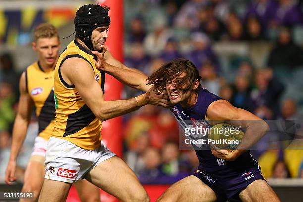 Lachie Weller of the Dockers fends off a tackle by Trent Cotchin of the Tigers during the round nine AFL match between the Fremantle Dockers and the...