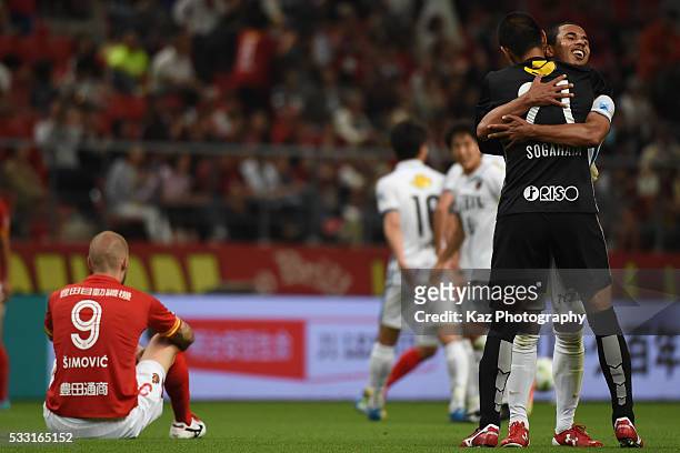 Bueno of Kashima Antlers celebrates the win with Hitoshi Sogahata of Kashima Antlers while Simovic of Nagoya Grampus shows his dejection as they lose...