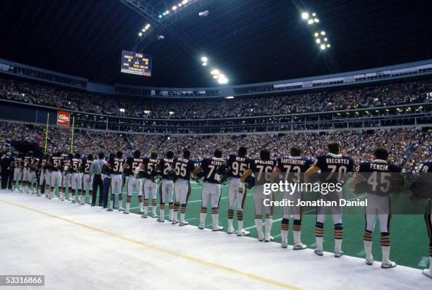 Chicago Bears players stand for the National Anthem before the game against the Dallas Cowboys at Texas Stadium on November 17, 1985 in Irving,...