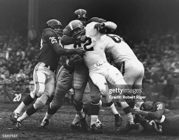 Members of the New York football Giants defensive squad take down American professional football player Jim Brown of the Cleveland Browns during a...