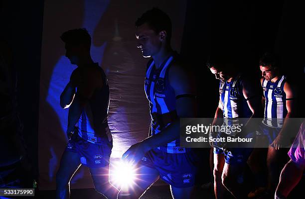 Scott Thompson of the Kangaroos and his teammates walk onto the field during the round nine AFL match between the North Melbourne Kangaroos and the...
