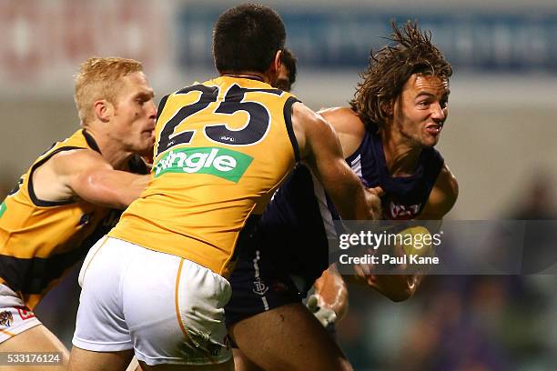 Lachlan Weller of the Dockers attempts to break from a tackle by Steven Morris and Troy Chaplin of the Tigers during the round nine AFL match between...