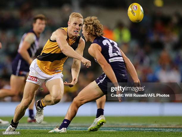 Steven Morris of the Tigers handballs during the round nine AFL match between the Fremantle Dockers and the Richmond Tigers at Domain Stadium on May...