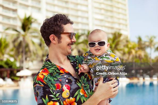 pai e filho com hawaian camisolas - hawaiian shirt imagens e fotografias de stock