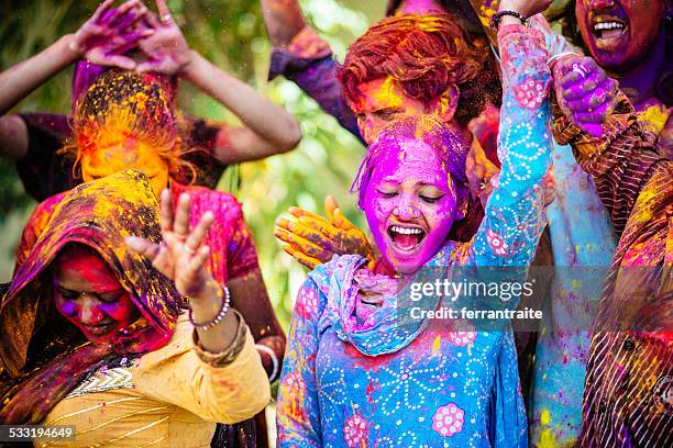 indian friends dancing covered on holi colorful powder in india - culture stockfoto's en -beelden