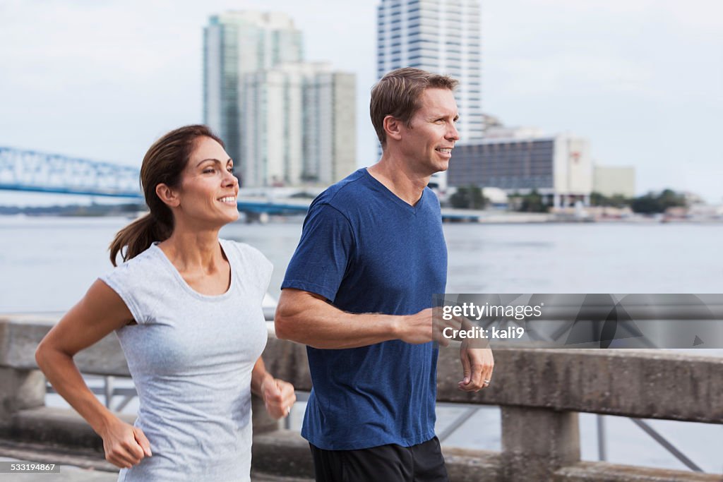 Mature couple jogging together along waterfront