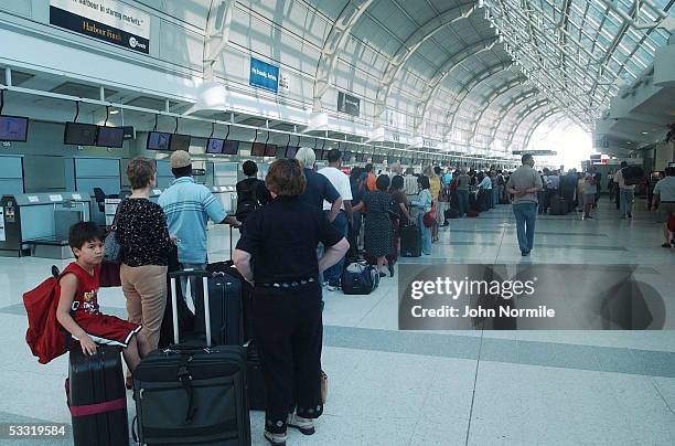 Air travelers wait in long lines in the terminal at Pearson International Airport a day after the crash of Air France flight 358 August 3, 2005 in...