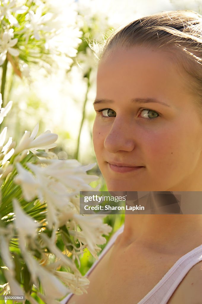 Teenage girl in bright sunlit garden
