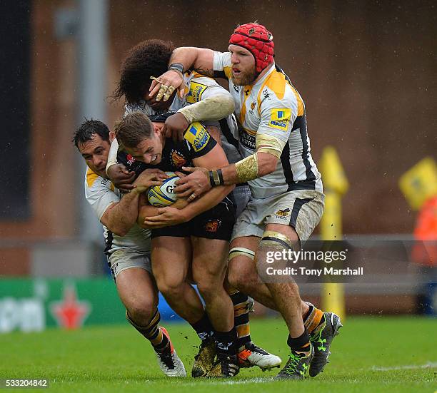 Gareth Steenson of Exeter Chiefs is tackled by George Smith, Ashley Johnson and James Haskell of Wasps during the Aviva Premiership semi final match...