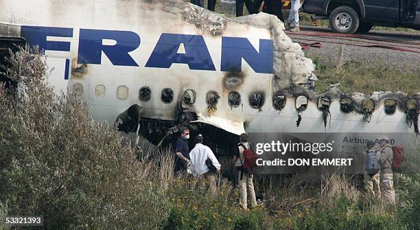 Officials view the wreckage of the Air France Airbus A340 at Toronto's Pearson International Airport 03 August 2005, one day after it skid off the...