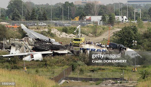 Officials view the wreckage of the Air France Airbus A340 at Toronto's Pearson International Airport 03 August 2005, one day after it skid off the...