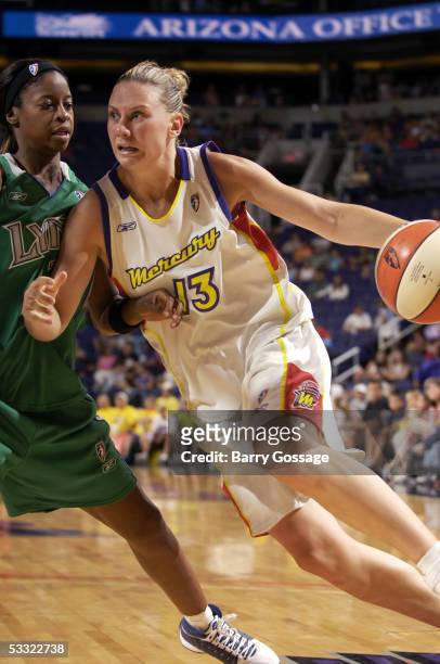 Penny Taylor of the Phoenix Mercury drives to the basket against Chandi Jones of the Minnesota Lynx on August 3, 2005 at America West Arena in...