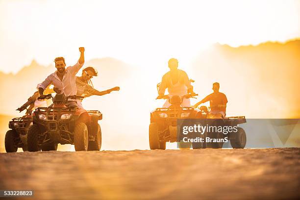 a divertir-se em quad bicicletas ao pôr do sol. - veículo todo o terreno imagens e fotografias de stock