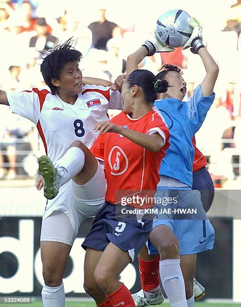 South Korean goalkeeper Kim Jung-Mi catches the ball as her teammate Hong Kyung-Suk and North Korean Jo Yun-Mi challenge each other during the East...