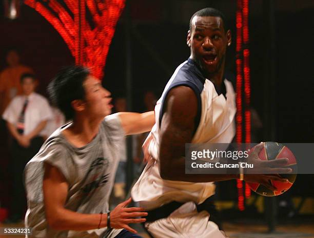 LeBron James of the Cleveland Cavaliers plays basketball with a young Chinese player during the Nike 2005 Battlegrounds event August 4, 2005 in...