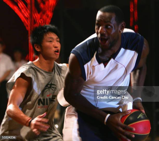LeBron James of the Cleveland Cavaliers plays basketball with a young Chinese player during the Nike 2005 Battlegrounds event August 4, 2005 in...