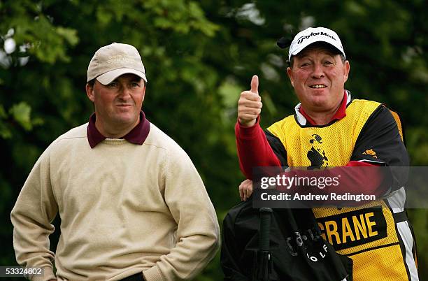 Damien McGrane of Ireland stands with his caddy "Edinburgh" Jimmy Rae on the 18th hole during the first round of The Johnnie Walker Championship at...