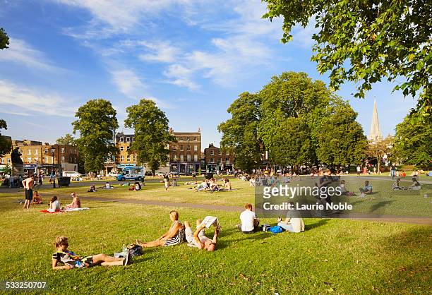 people relaxing in the sun, clapham common - uk city stockfoto's en -beelden