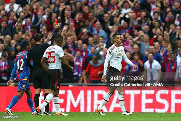 Referee Mark Clattenburg shows a red card to Chris Smalling of Manchester United during The Emirates FA Cup final match between Manchester United and...