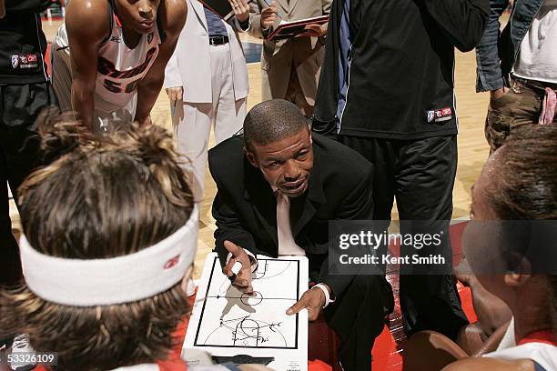 Head coach Muggsy Bogues of the Charlotte Sting tells his players the new plays during the game against the Sacramento Monarchs on August 4, 2005 at...