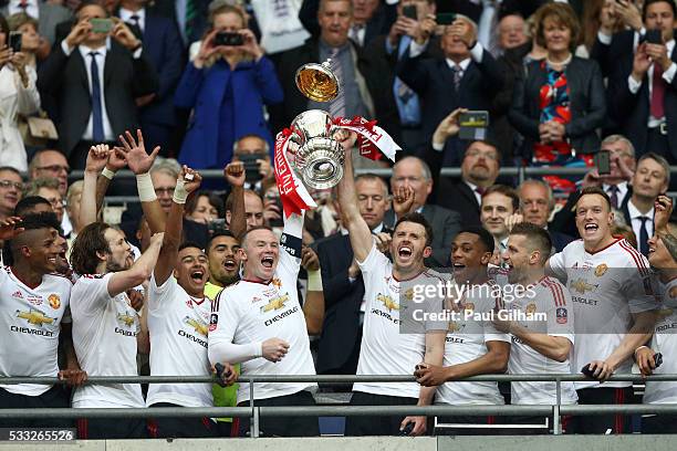 Wayne Rooney and Michael Carrick of Manchester United lift the trophy after winning The Emirates FA Cup Final match between Manchester United and...