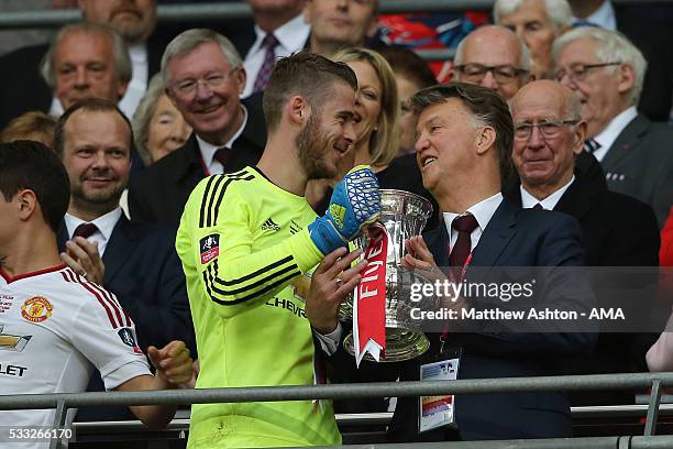 Manchester United Managr Louis van Gaal and David de Gea hold the trophy following their side's 1-2 victory as Sir Alex Ferguson and David Gill look...