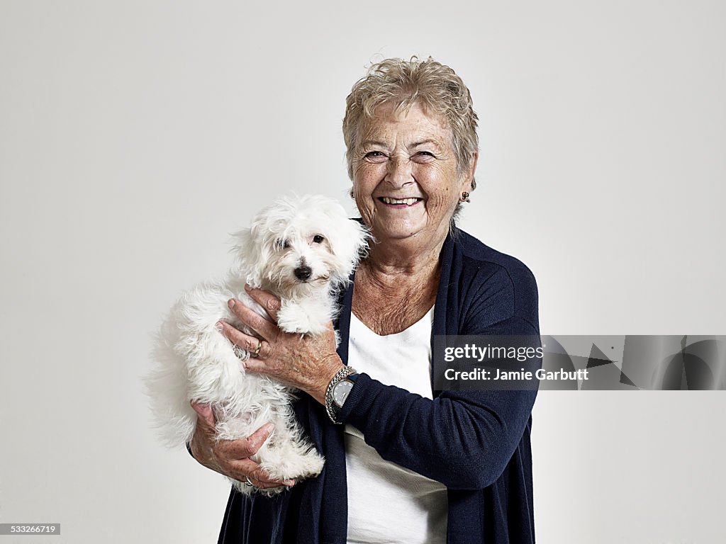 Elderly women smiling holding her puppy