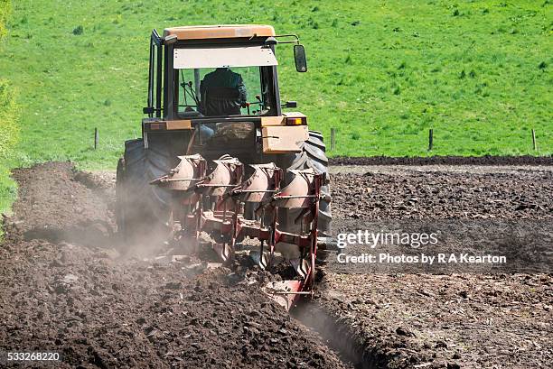 tractor ploughing a field on a sunny spring day. - cheshire england stock pictures, royalty-free photos & images