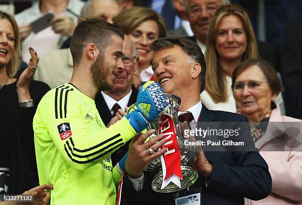 David De Gea of Manchester United passes the trophy to Louis van Gaal manager of Manchester United after winning The Emirates FA Cup Final match...