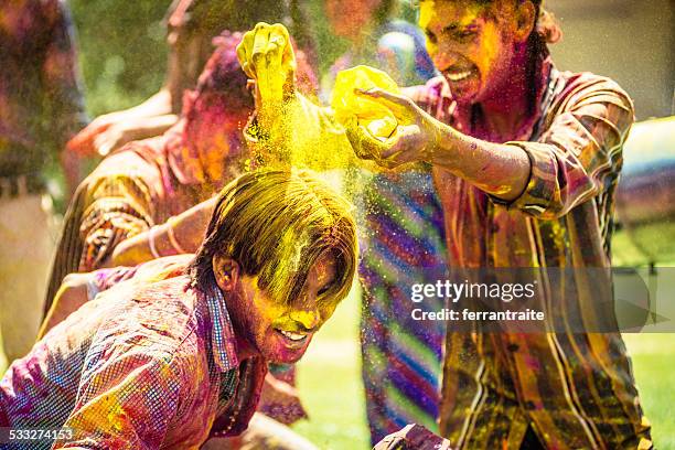 amigos indios tirando holi colorido polvo en cada - powder throw fotografías e imágenes de stock