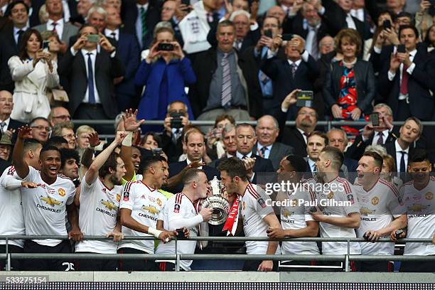 Wayne Rooney and Michael Carrick of Manchester United kiss the trophy after winning The Emirates FA Cup Final match between Manchester United and...